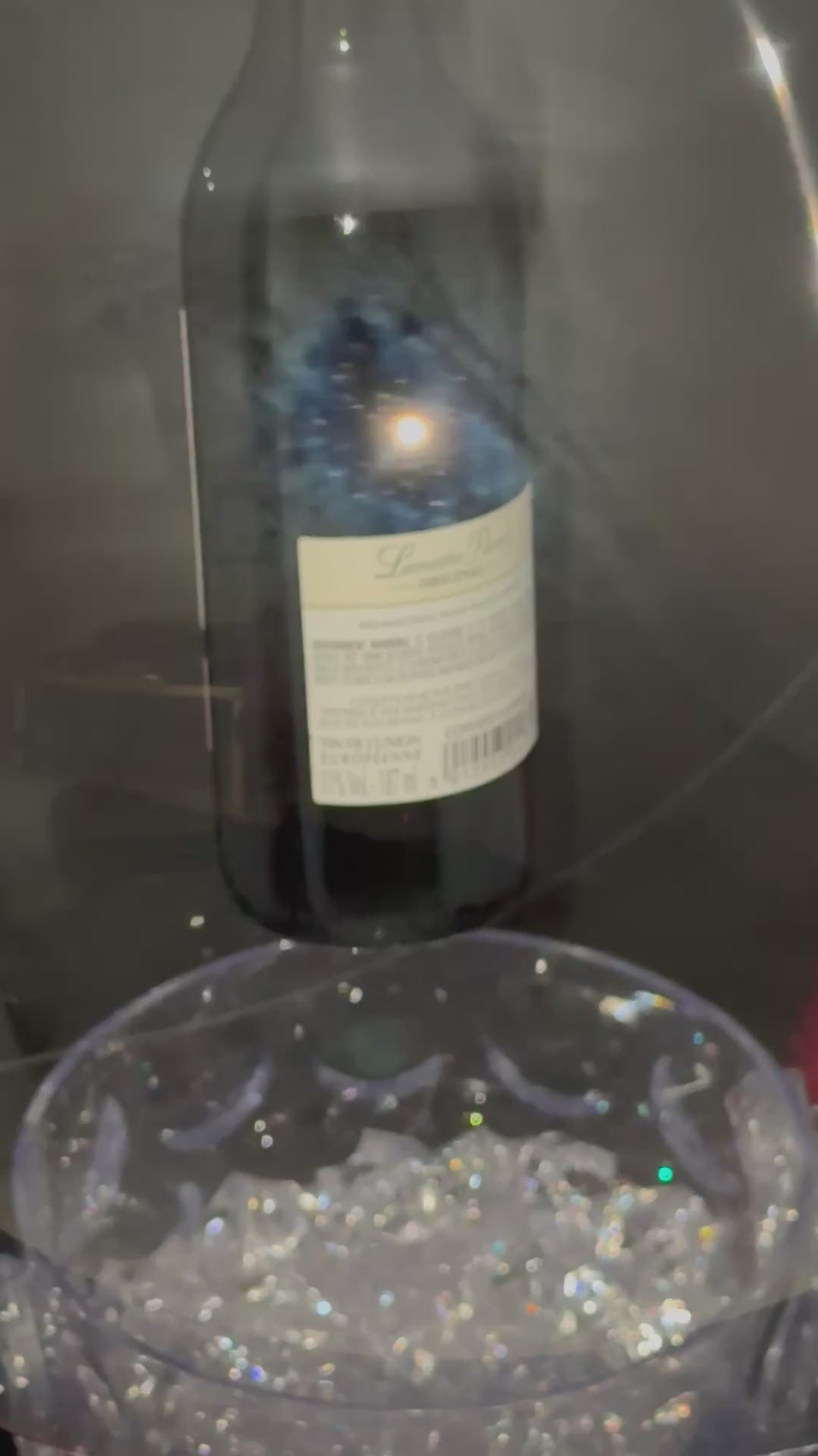 The Signature Luxe Bottle Bubble. This elegant gift turns  your bottles of choice into a stunning floating centerpieces. Ribbons of various colors gather at the top in a delicate bow, adding a graceful touch.